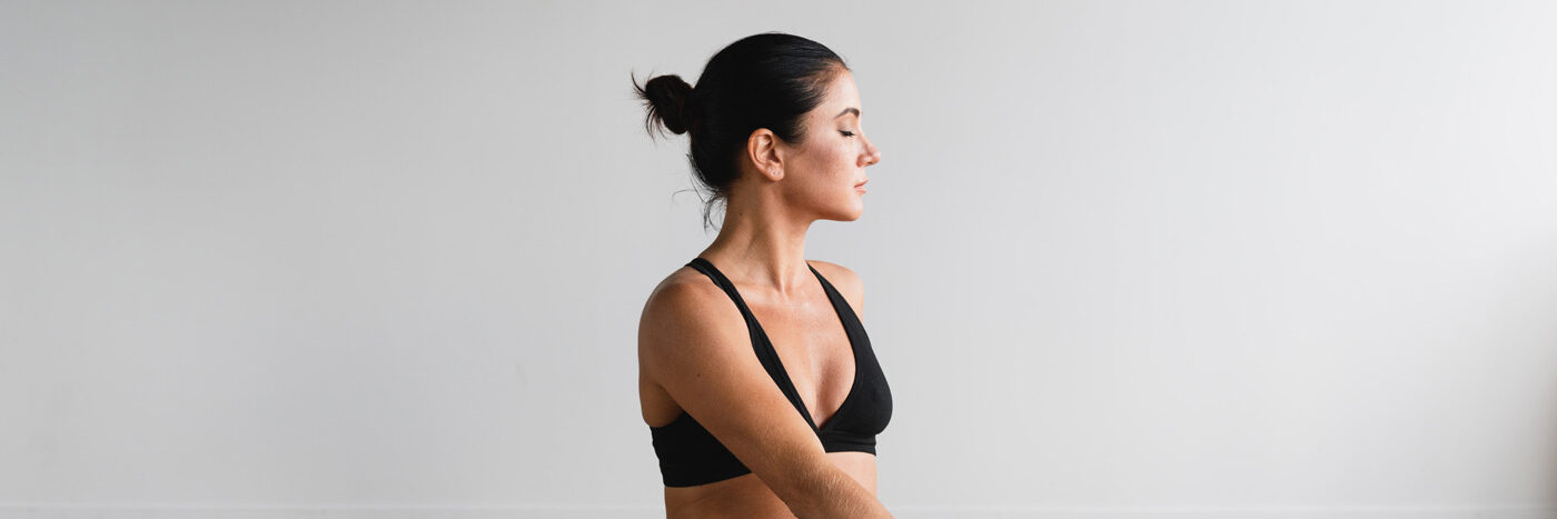 Frau während einer Yoga Übung auf einer Turnmatte